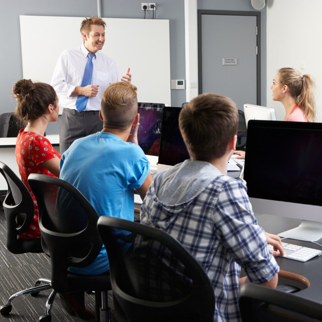 A teacher and students in a computer lab.