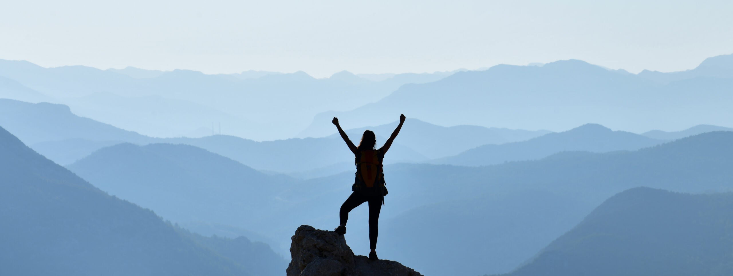 A person on top of a mountain, showing they have achieved their self-advocacy goals.