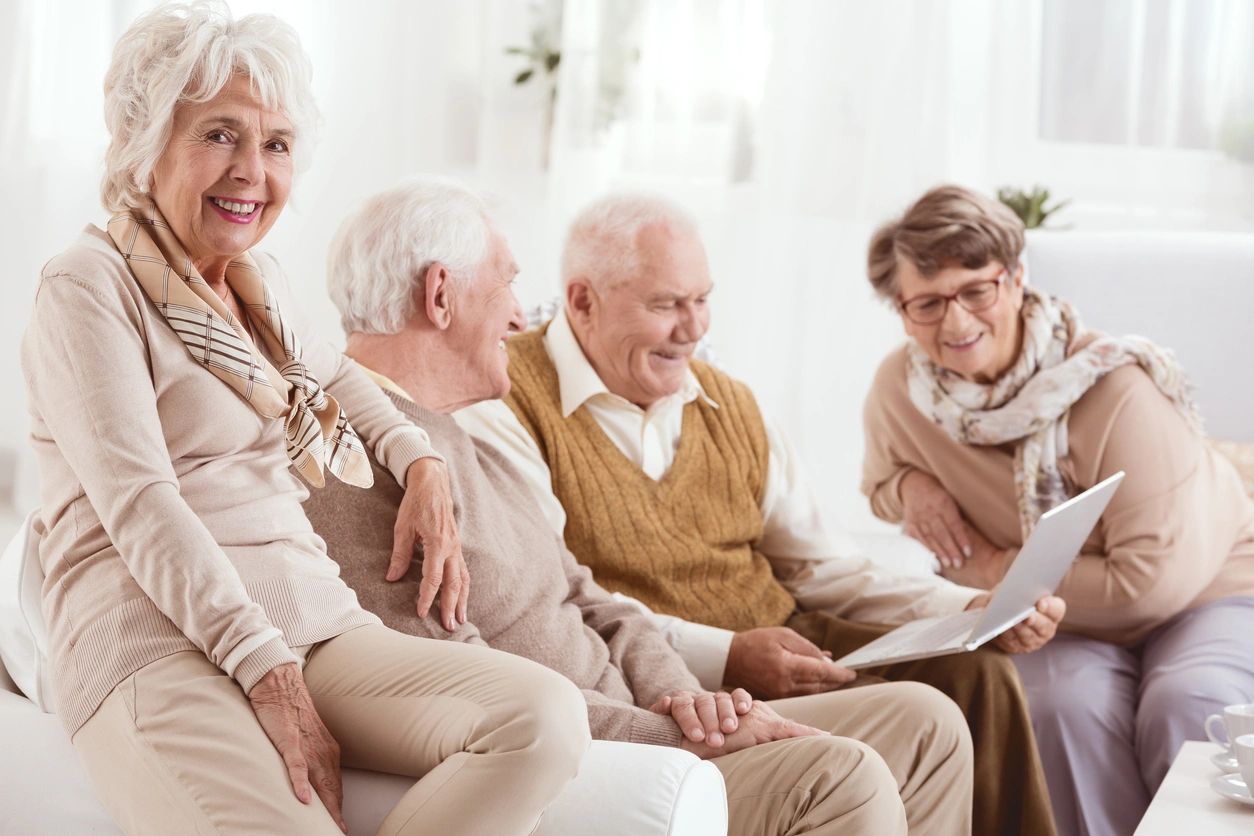 A small group of older self-advocates supporting each other with healthy aging. One person is holding a laptop.