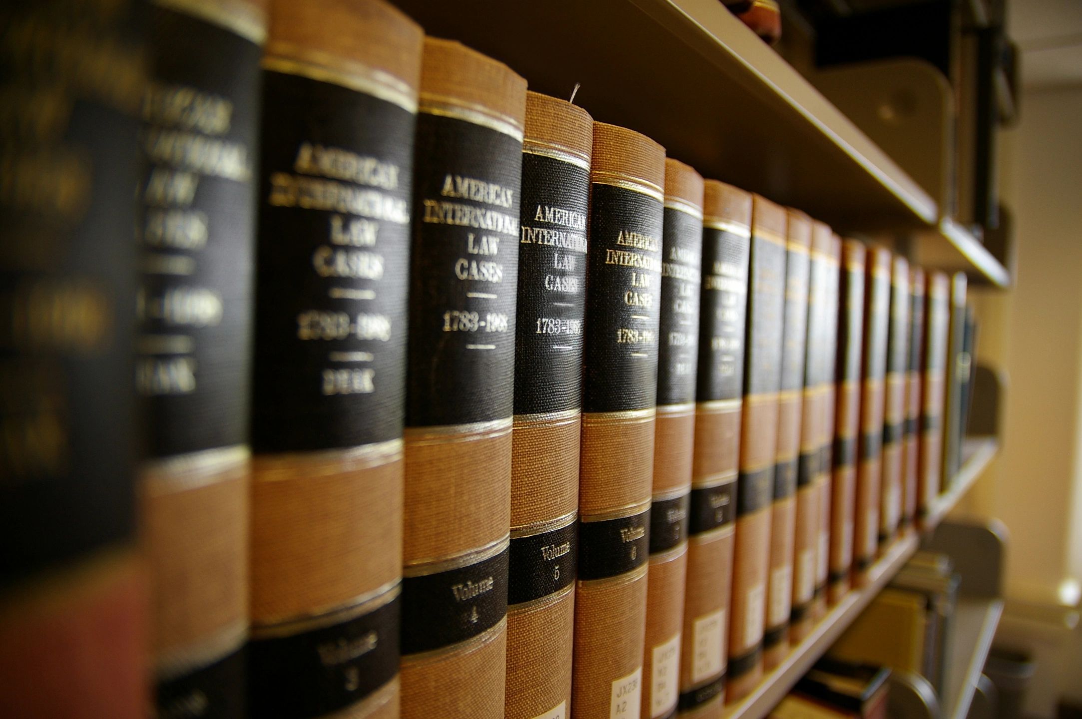 A row of old law books line a bookshelf. These old law books remind the reader of how old Social Security rules hurt people with disabilities.